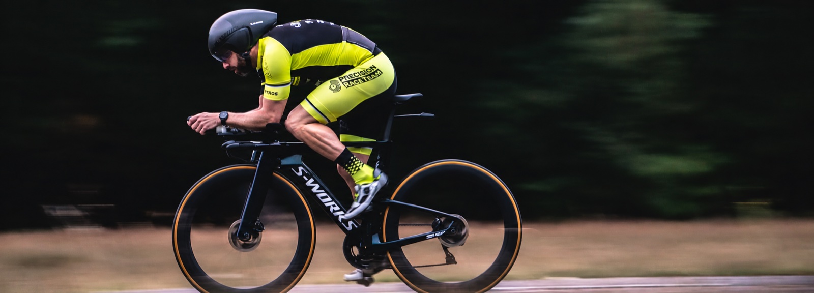 Precision athlete wearing an aero helmet on a time-trial bike